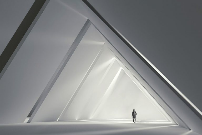 man walking in triangle shapes building